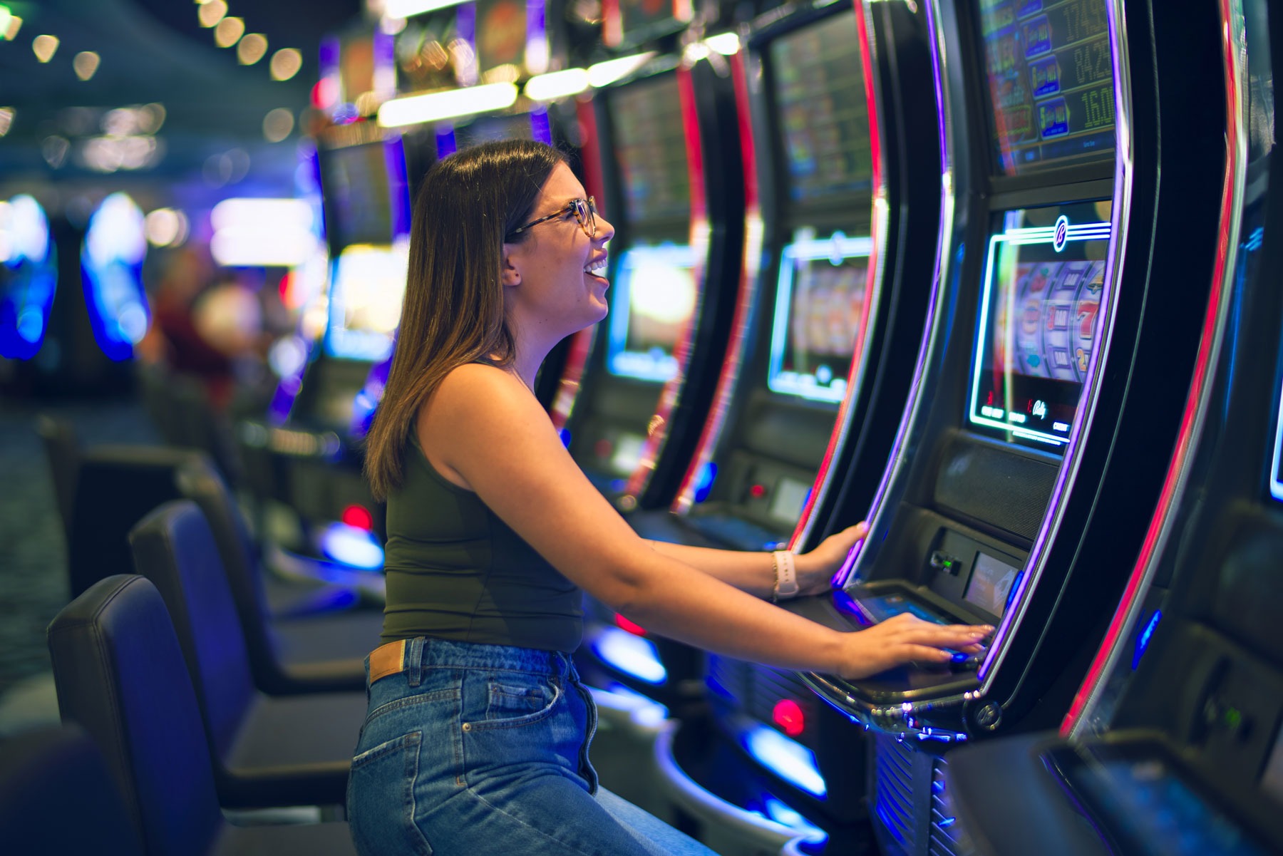 Slots - Younger woman excited to win big on one of the many slots machines