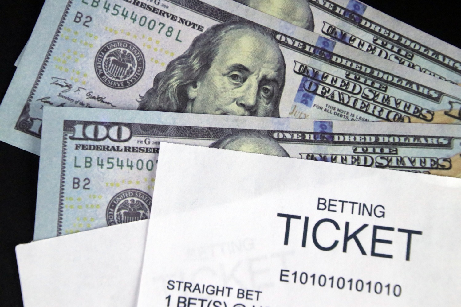 Sportsbook - House Rules - Stack of 100 dollar bills with betting ticket