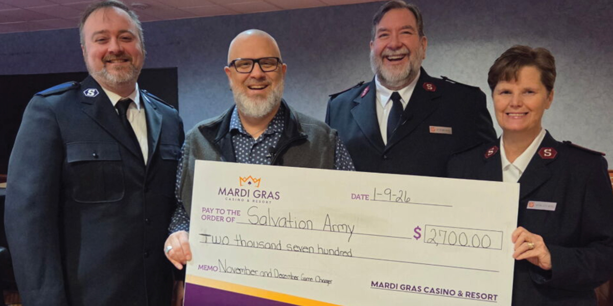 Salvation Army and Mardi Gras Team members holding a donation check
