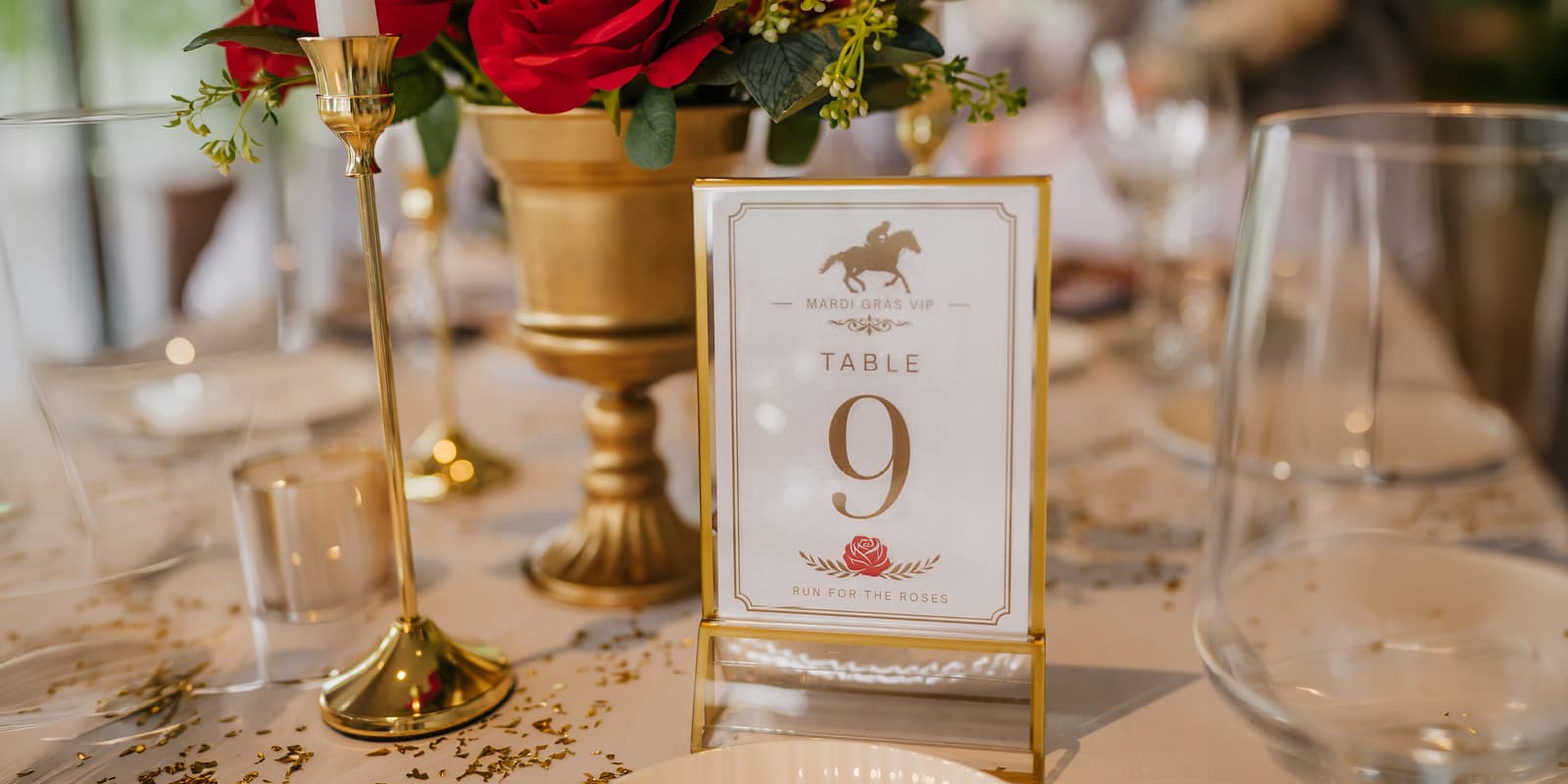 Table 9 displaying red roses, glassware, and cutlery