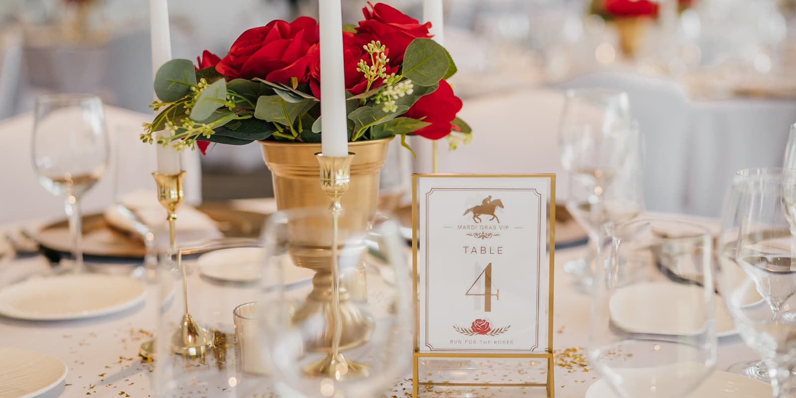 Table 4 displaying red roses, glassware, and cutlery