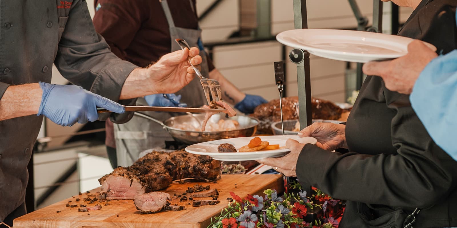 Carving station at event serving guests meat.